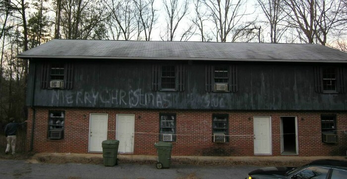 House Hacking - before pic - outside of fourplex - merry christmas spraypainted