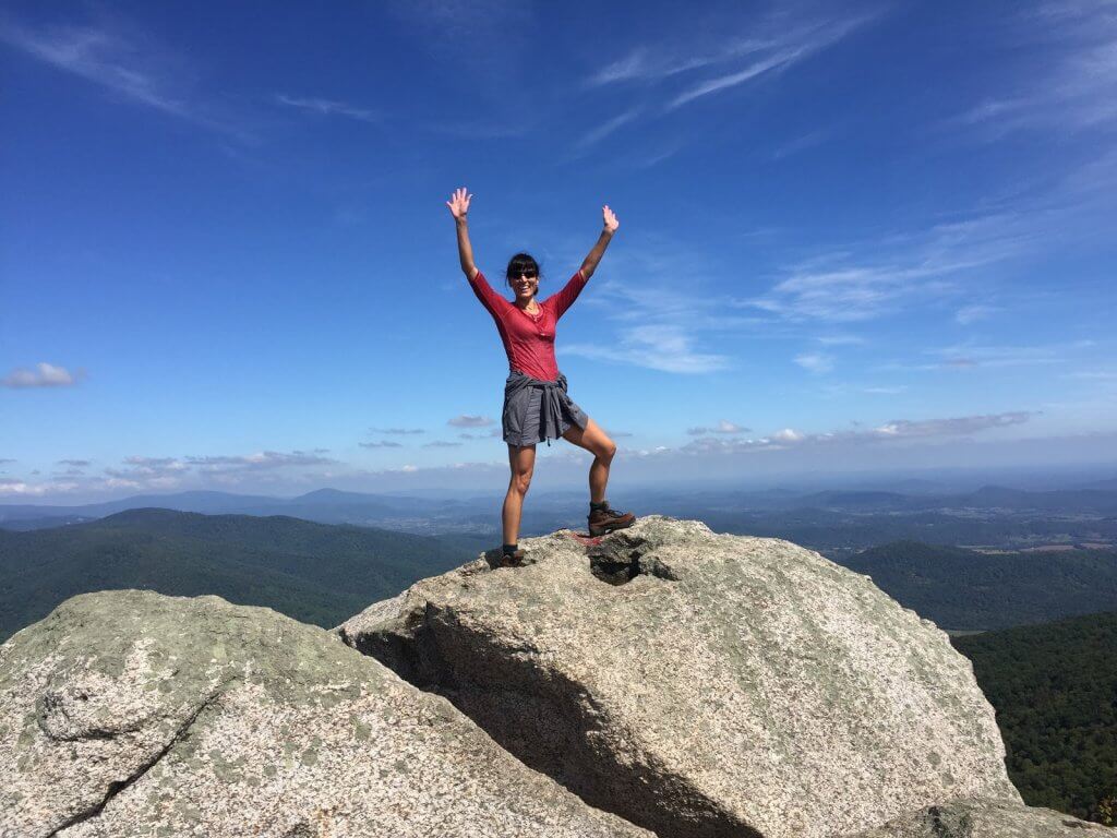 Kat hiking to top of rock - How a Busy Mom Found Financial Freedom Through Real Estate Investing