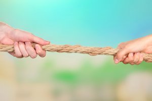 tug of war hands - how to buy an investment property